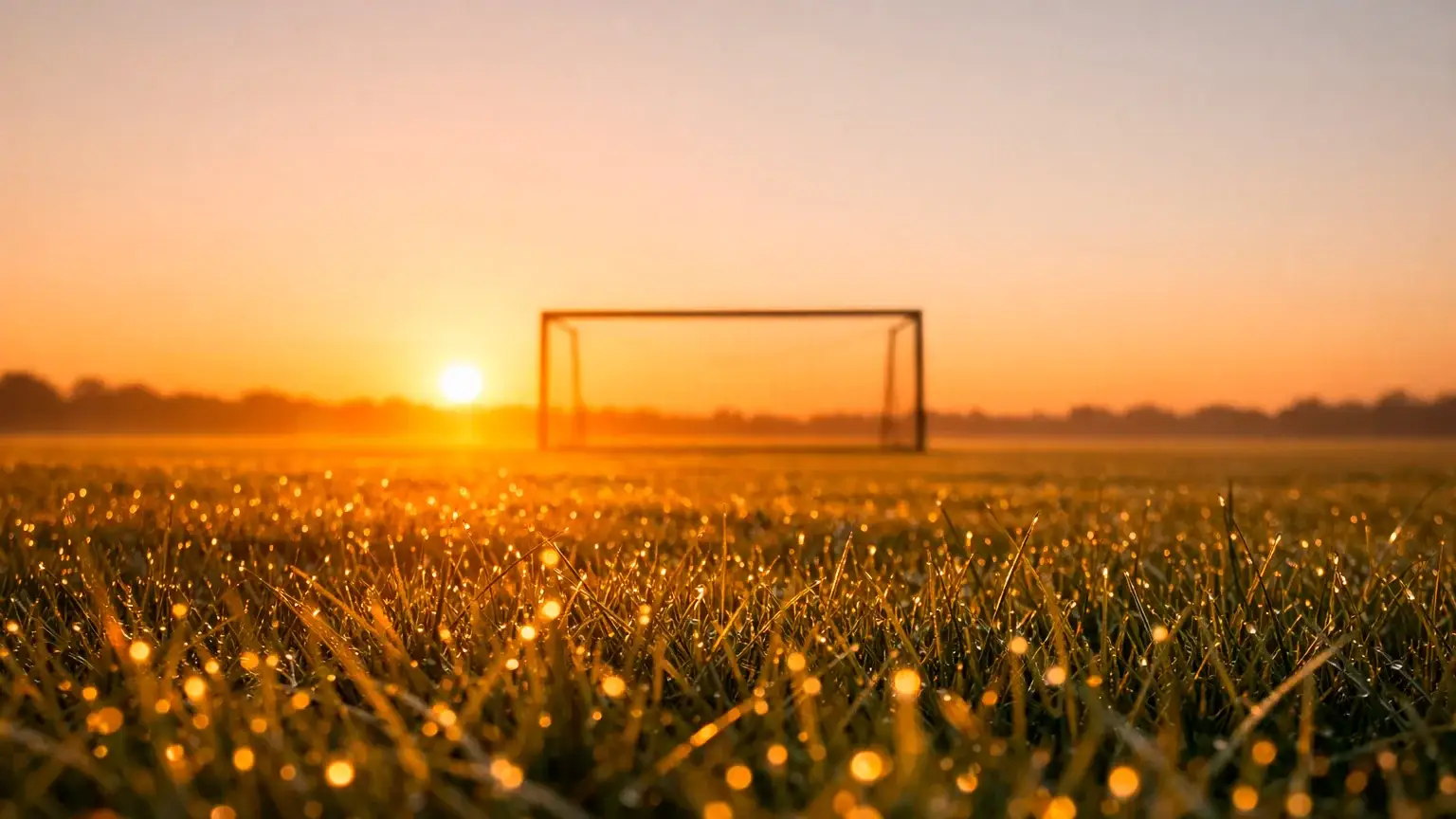 Ruhiger Sonnenaufgang über einem leeren Fußballplatz symbolisiert Neuanfang und Kontrolle